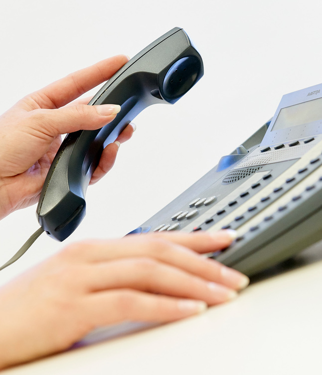 Frau hebt Telefonhöhrer ab