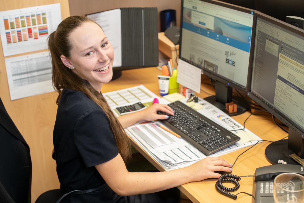 Mitarbeiterin am Computer, tippt etwas in die Tastatur